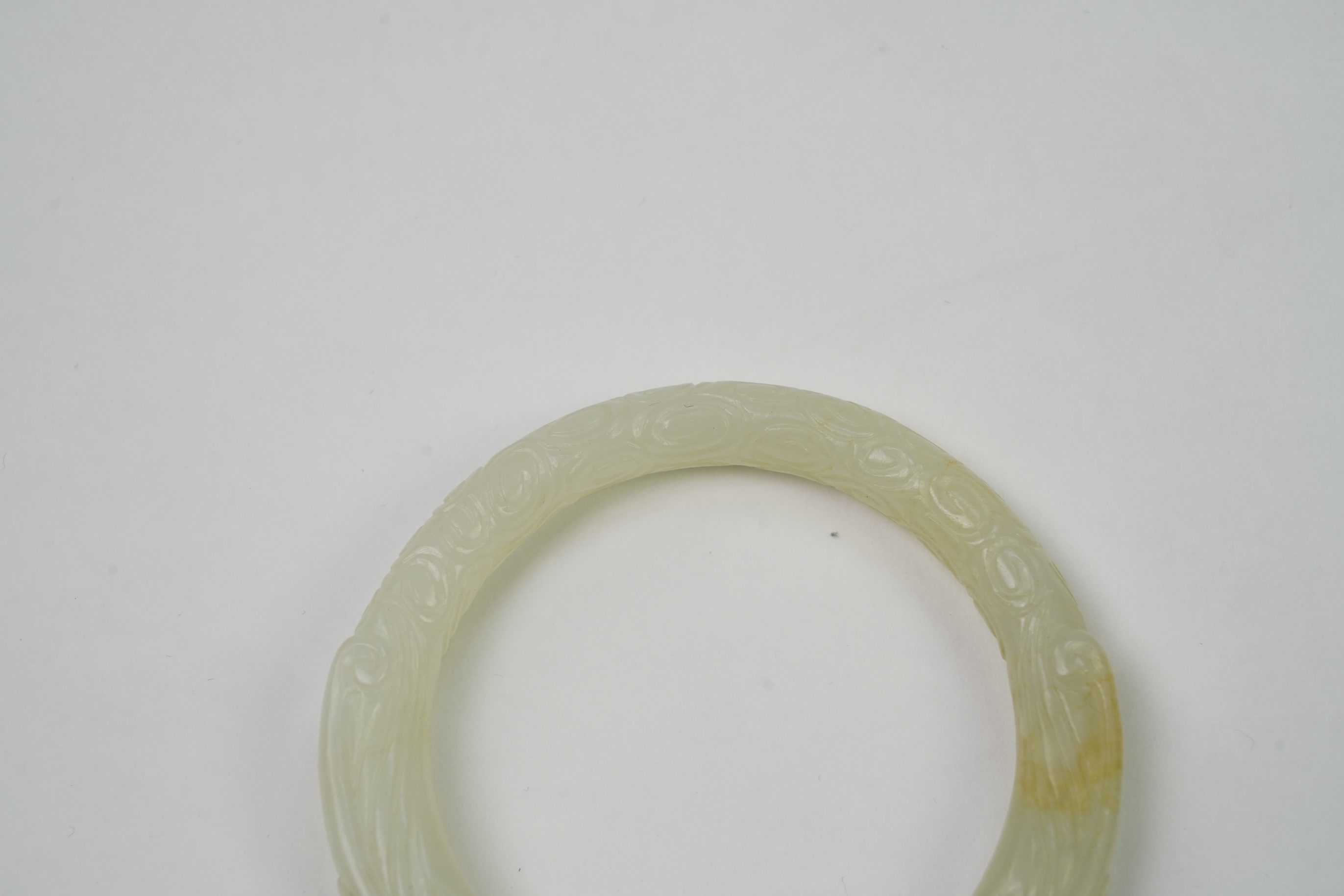 A Chinese pale celadon jade ’dragon’ bangle